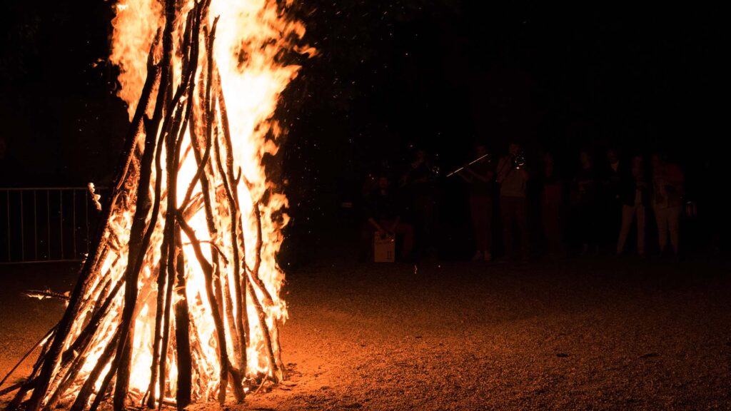 Hoguera de Midsummer en el Reino Unido rodeada de personas celebrando el solsticio de verano